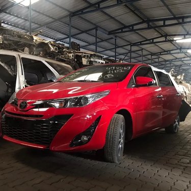 Pátio da Nil Motor's com veículo vermelho e estoque de peças